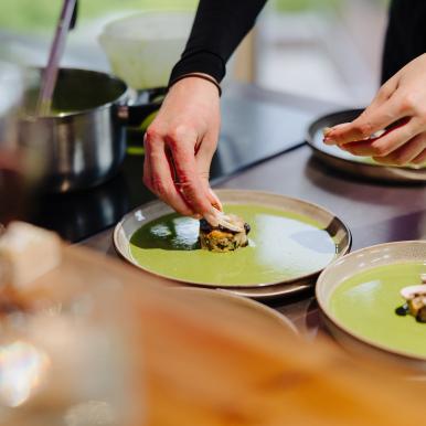 Guest plating up a dish in the Demonstration Kitchen. 