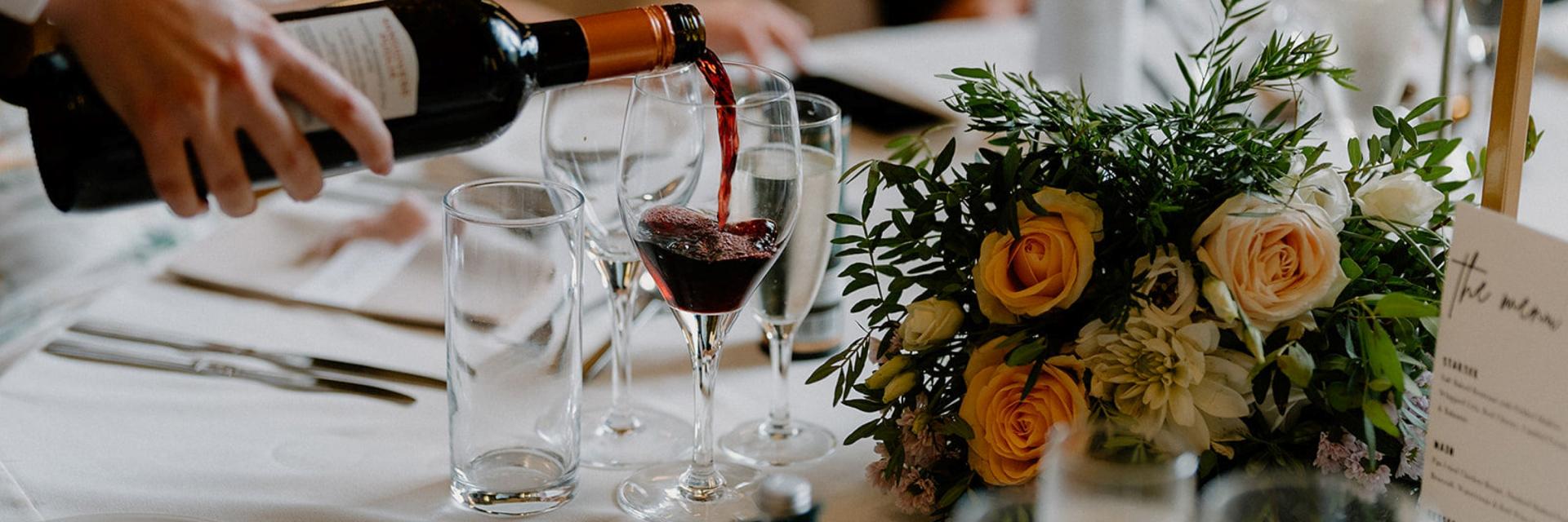 Red wine being poured at a table in the Caledonian Hall. 