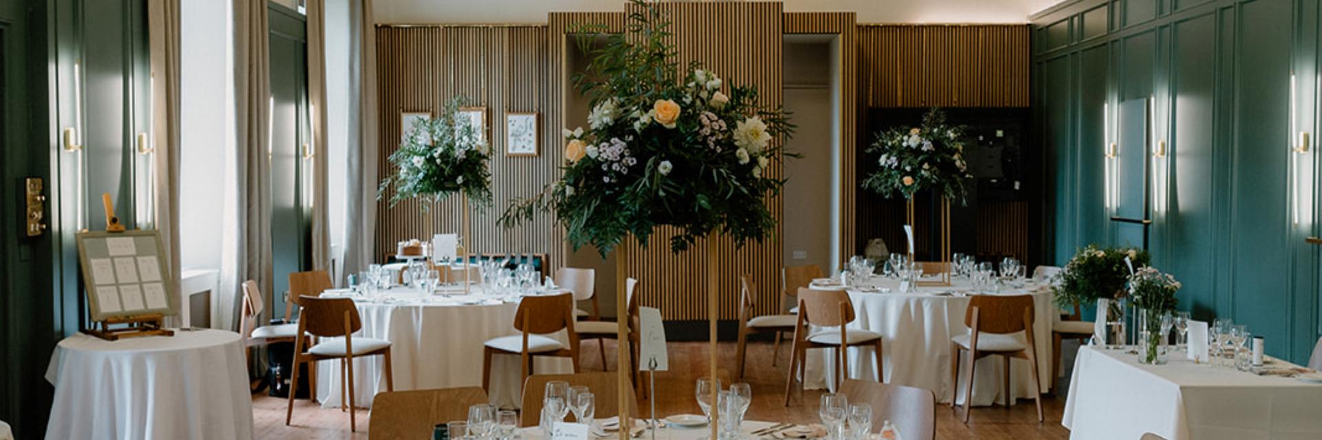 Wedding setup with cream linens and florals in the Caledonian Hall.